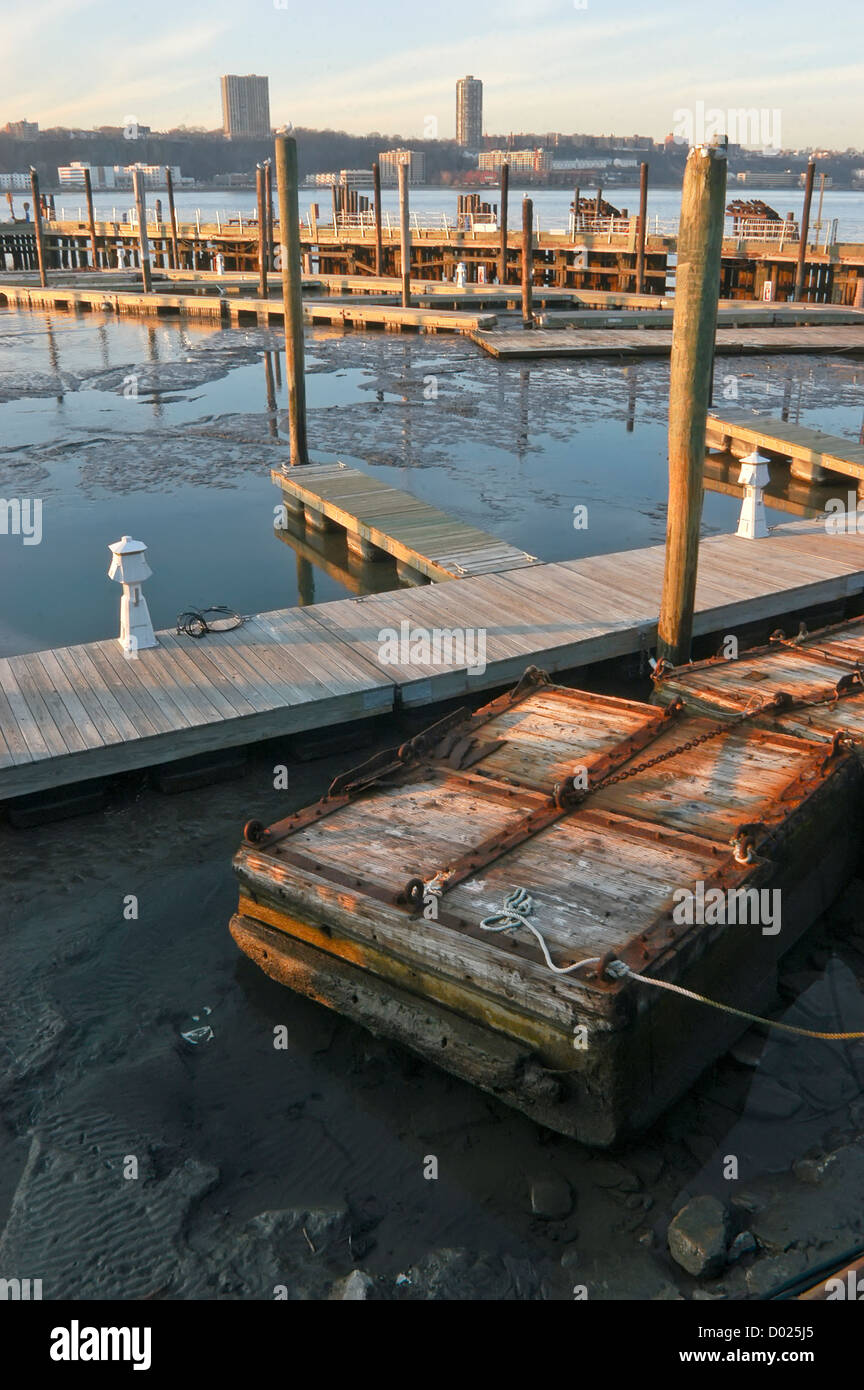 Schwimmdocks sitzen auf dem schlammigen Flussbett bei Ebbe an der 79th Street Boat Basin im Riverside Park Stockfoto