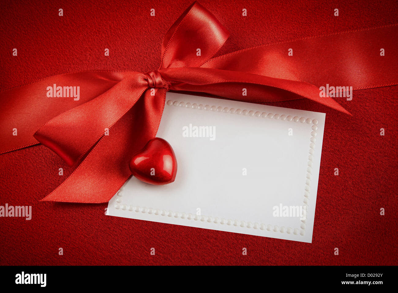 Rote Schleife und weiße Karte für Geschenk auf reichen satin Hintergrund Stockfoto