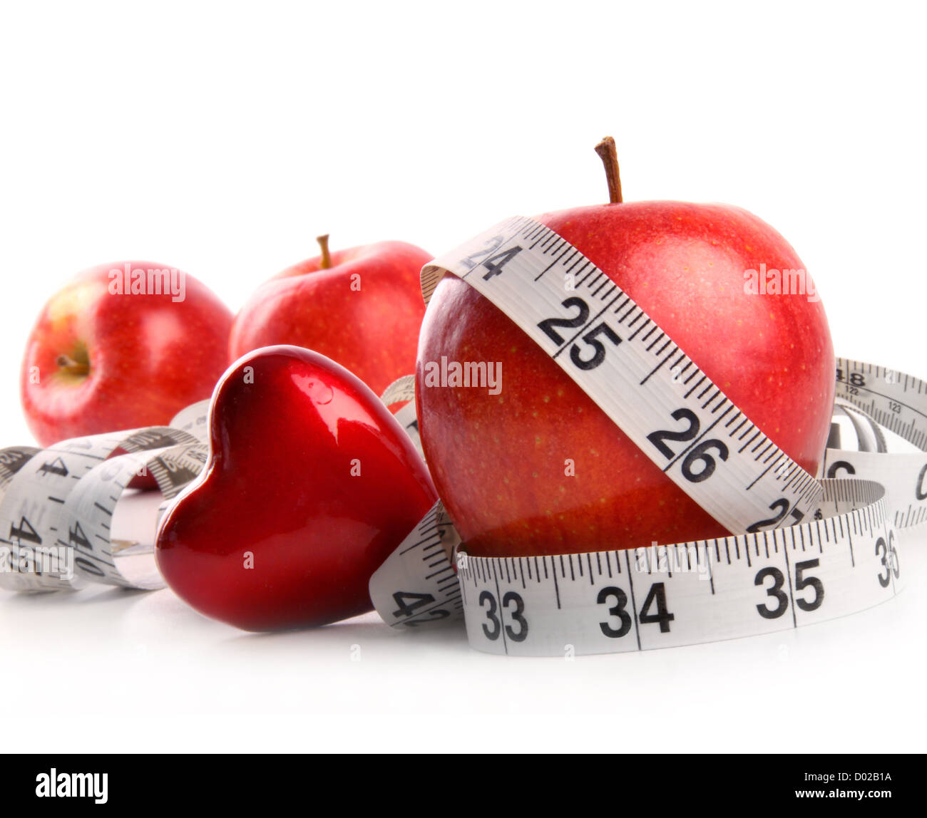 Rote Äpfel, Herz und Maßband auf weißem Hintergrund Stockfoto