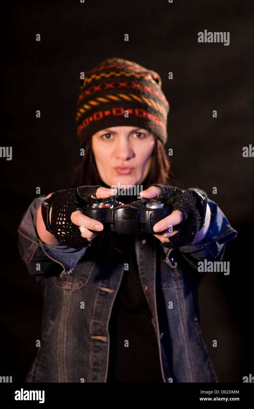 Frau gamer mit Joystick auf dunklem Hintergrund Stockfoto
