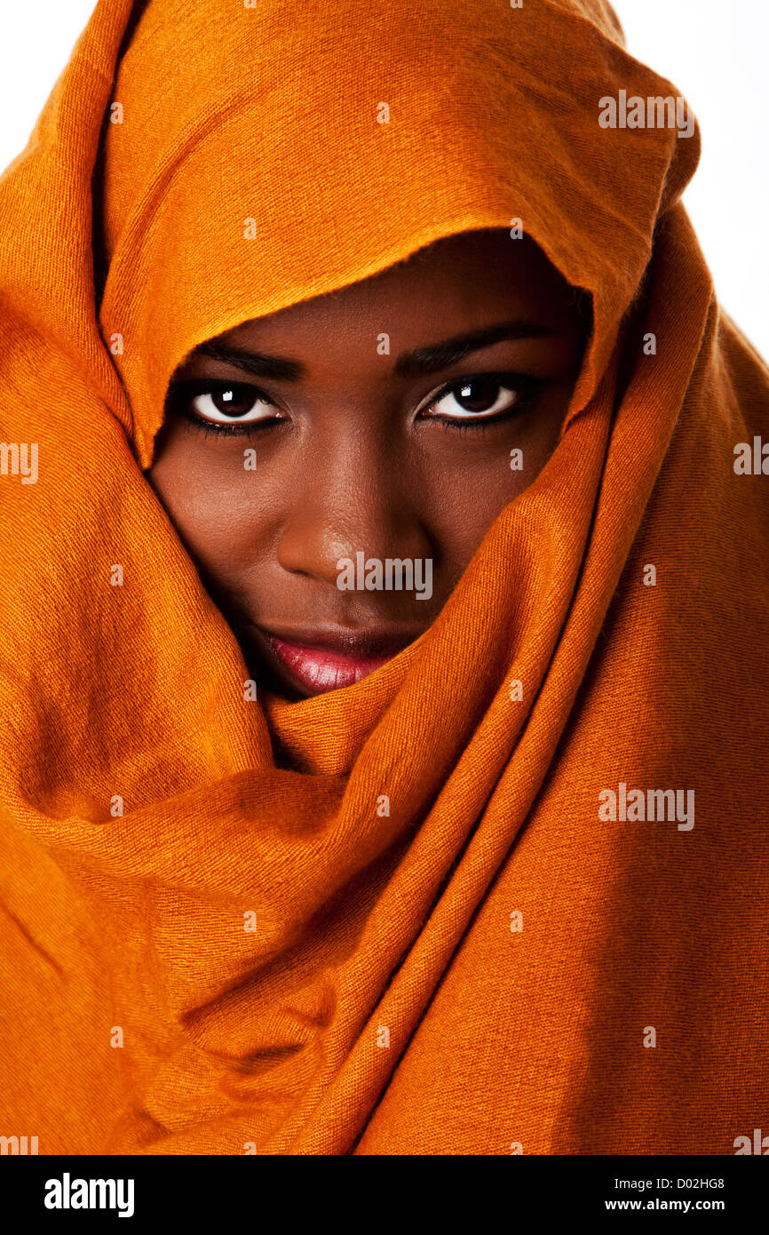 Schöne geheimnisvolle afrikanische nomadenhaftes weibliches Gesicht in ockerfarbenen Erde Ton Kopf wickeln Schal suchen. Stockfoto