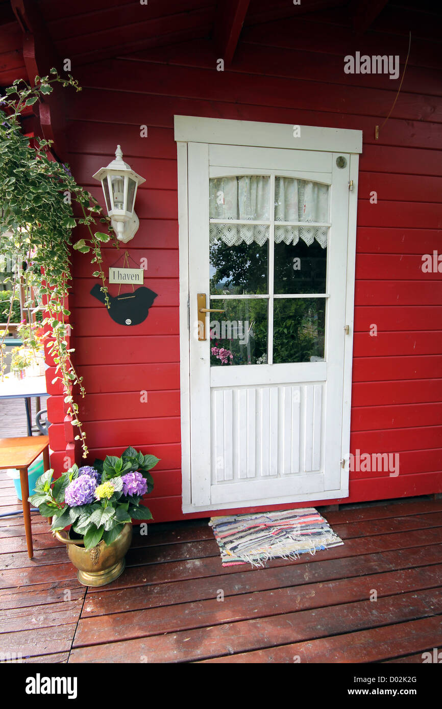 Weiße Tür auf eine rote Holzhütte. Stockfoto