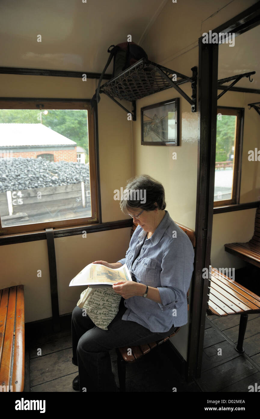 Welshpool & Llanfair Light Railway, eine Frau Passagier Zeitung lesen Stockfoto