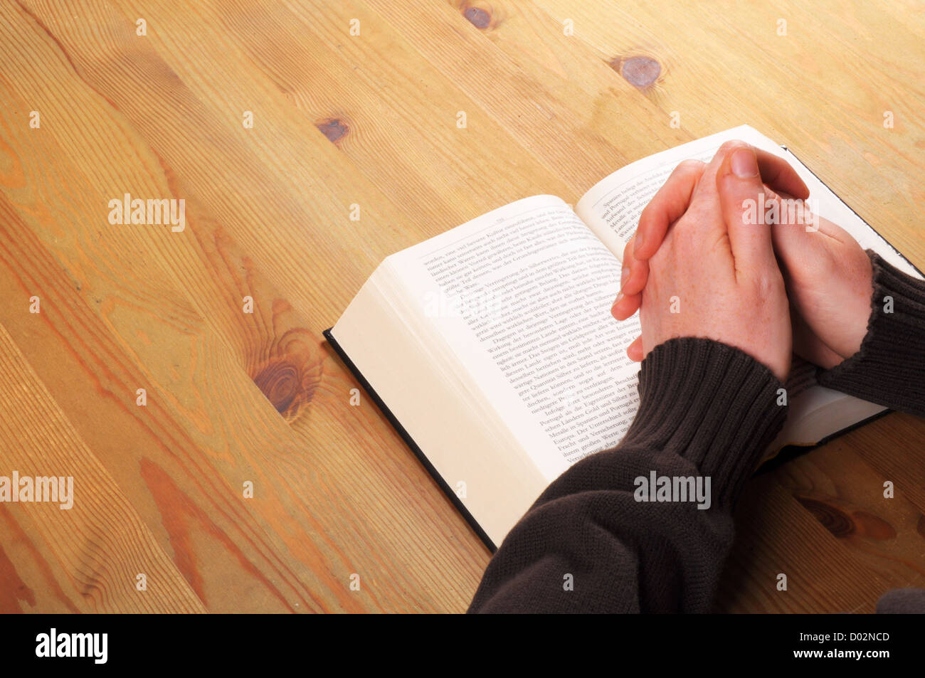Betende Hände und Buch mit christlichen Religion Konzept Stockfoto