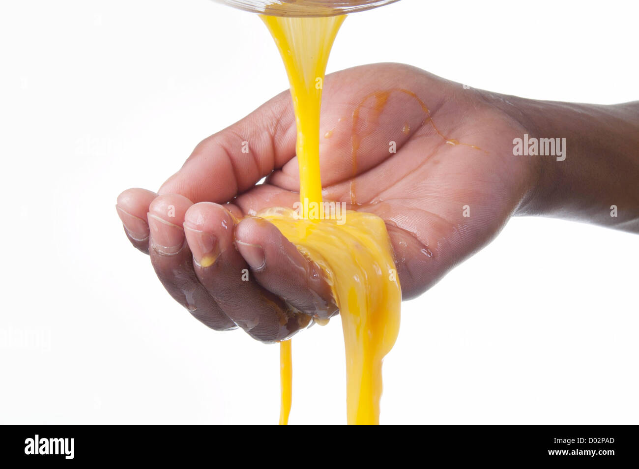 Geschlagenem Eigelb gießen in offene hand Stockfoto