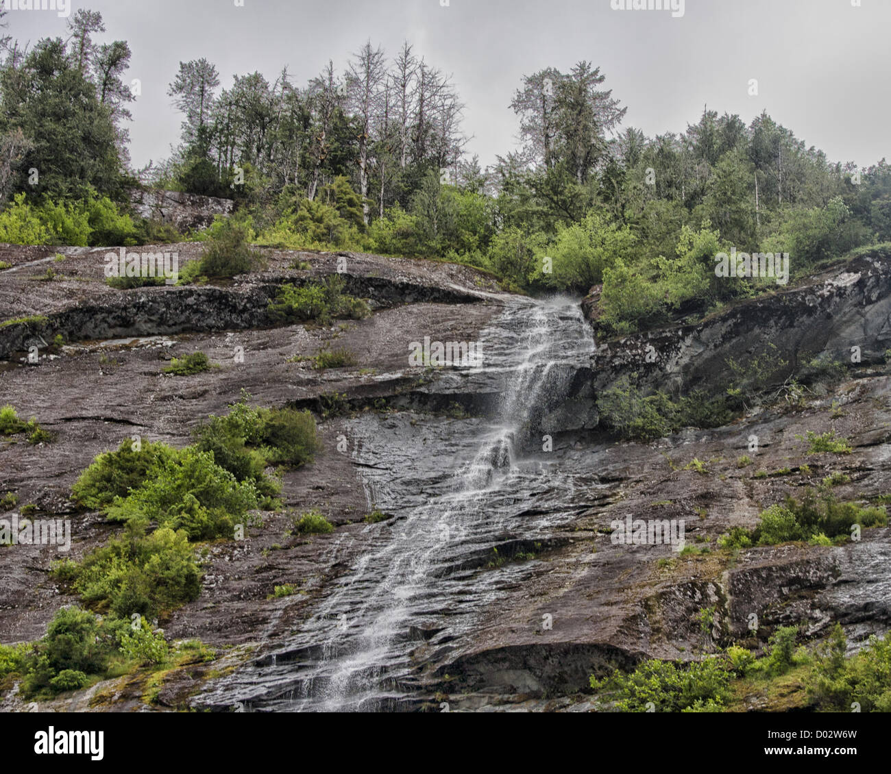 6. Juli 2012 - Ketchikan Gateway Borough, Alaska, Mauern uns - dramatische Wasserfälle Kurs nach unten die hoch aufragenden Granit in Misty Fjords Rudyerd Bay. Geformt durch massive Gletscher Aktion 50 bis 70 Millionen Jahren, sie steigen so hoch wie 3.000 ft (900 m) und Zähler, die durch die immergrünen Regenwälder ausgeglichen sind. Misty Fjords National Monument und Wildnis-Gebiet, entlang der Inside Passage Küste der südöstlichen Alaska wird von der US Forest Service verwaltet und umfasst 2.294.343 Hektar (9.246 km) der Tongass National Forest, der größte Wildnis in Alaska National Forest und ist nur mit dem Wasserflugzeug erreichbar Stockfoto