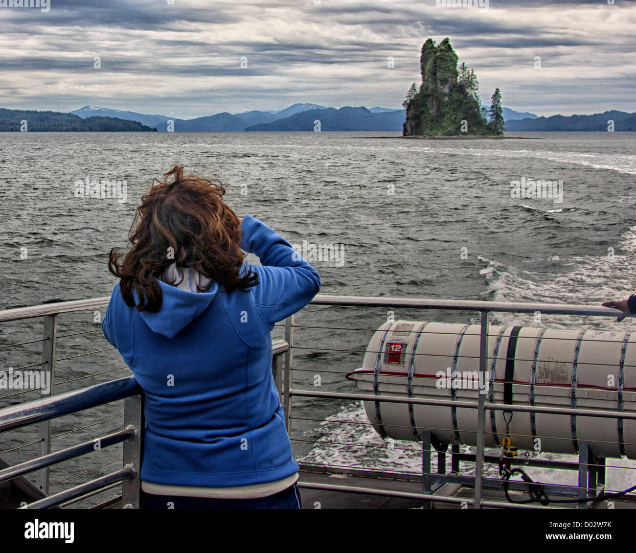 6. Juli 2012 - Ketchikan Gateway Borough, Alaska, USA - Urlauber auf einem Ausflugsboot sehen und fotografieren die neue Eddystone Rock in Misty Fjords Behm Canal. 237-Fuß hohen Basalt Säule, der Überrest eines vulkanischen Steckers erstellt von Lava vor 5 Millionen Jahren seine gebrochene, planlose Textur gibt an, dass es gehörte einem Vulkanschlot wo stieg Magma immer wieder an die Oberfläche der Erde. Immergrüne Wachstum hat sich heute auf dem Felsen etabliert. Misty Fjords National Monument und Wildnis-Gebiet, entlang der Inside Passage Küste der südöstlichen Alaska wird verwaltet von der US Forest Service und co Stockfoto