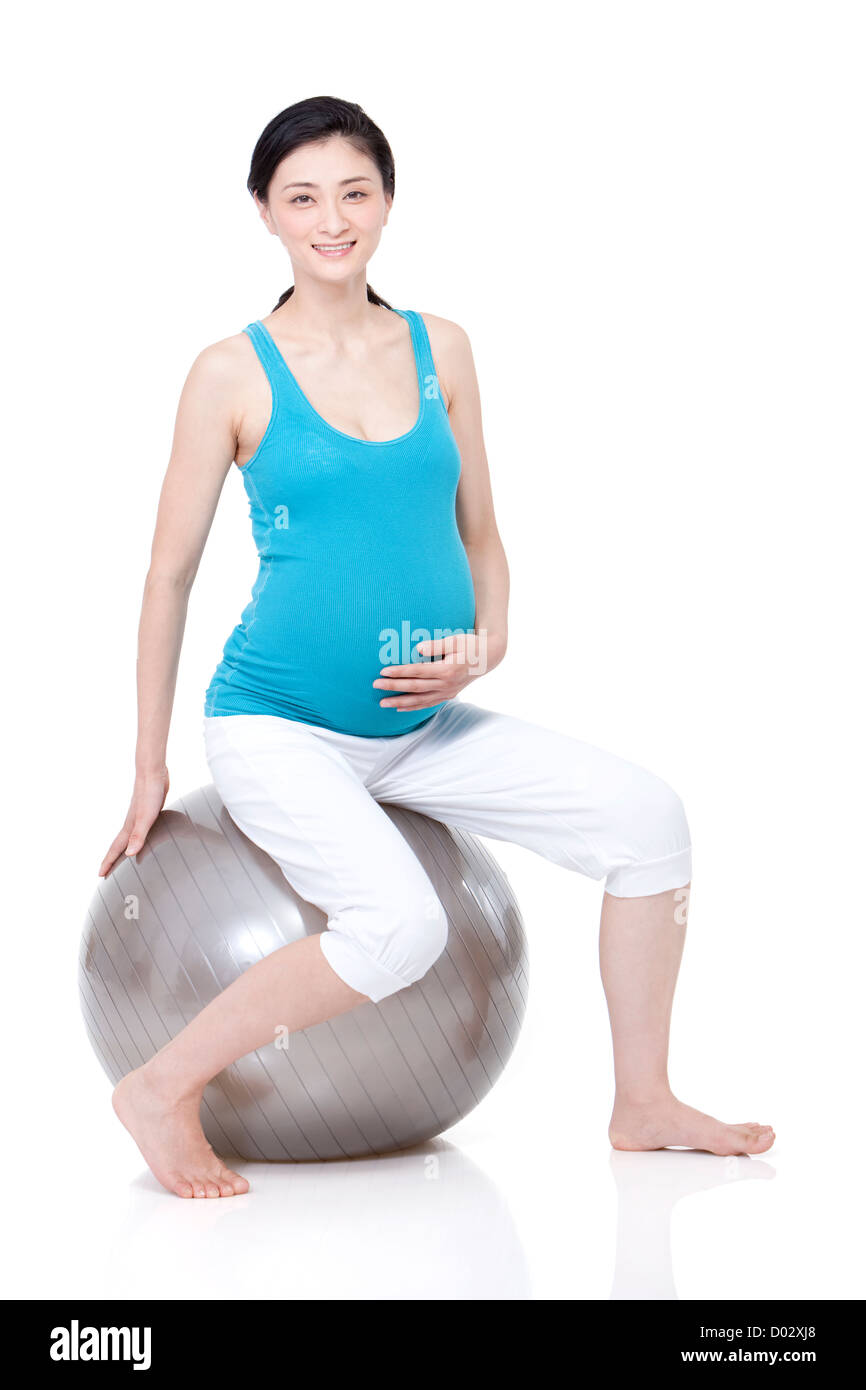 Junge schwangere Frau sitzen auf Fitness-ball Stockfoto