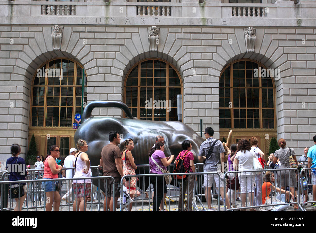 Touristen Line-up, Fotografieren mit der Wall Street Bull untere Manhattan New York City lassen Stockfoto