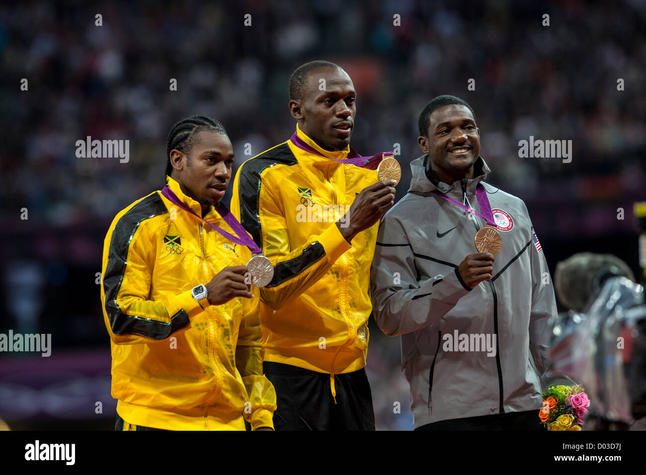 Usain Bolt (JAM) mit seiner Goldmedaille für den Sieg der Männer 100m mit Yohan Blake (JAM) - Silber und Justin Gatlin (USA) - Bronze Stockfoto