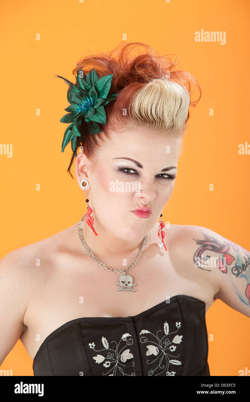 Retro-Stil Frau auf orangem Hintergrund schrumpft ihre Nase Stockfoto