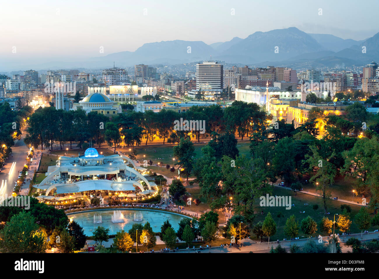 Abenddämmerung Ansicht von Tirana, der Hauptstadt von Albanien. Im Vordergrund steht Rinia Park. Stockfoto