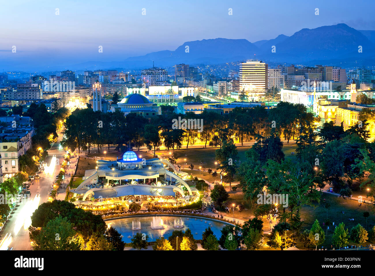 Abenddämmerung Ansicht von Tirana, der Hauptstadt von Albanien. Im Vordergrund steht Rinia Park. Stockfoto