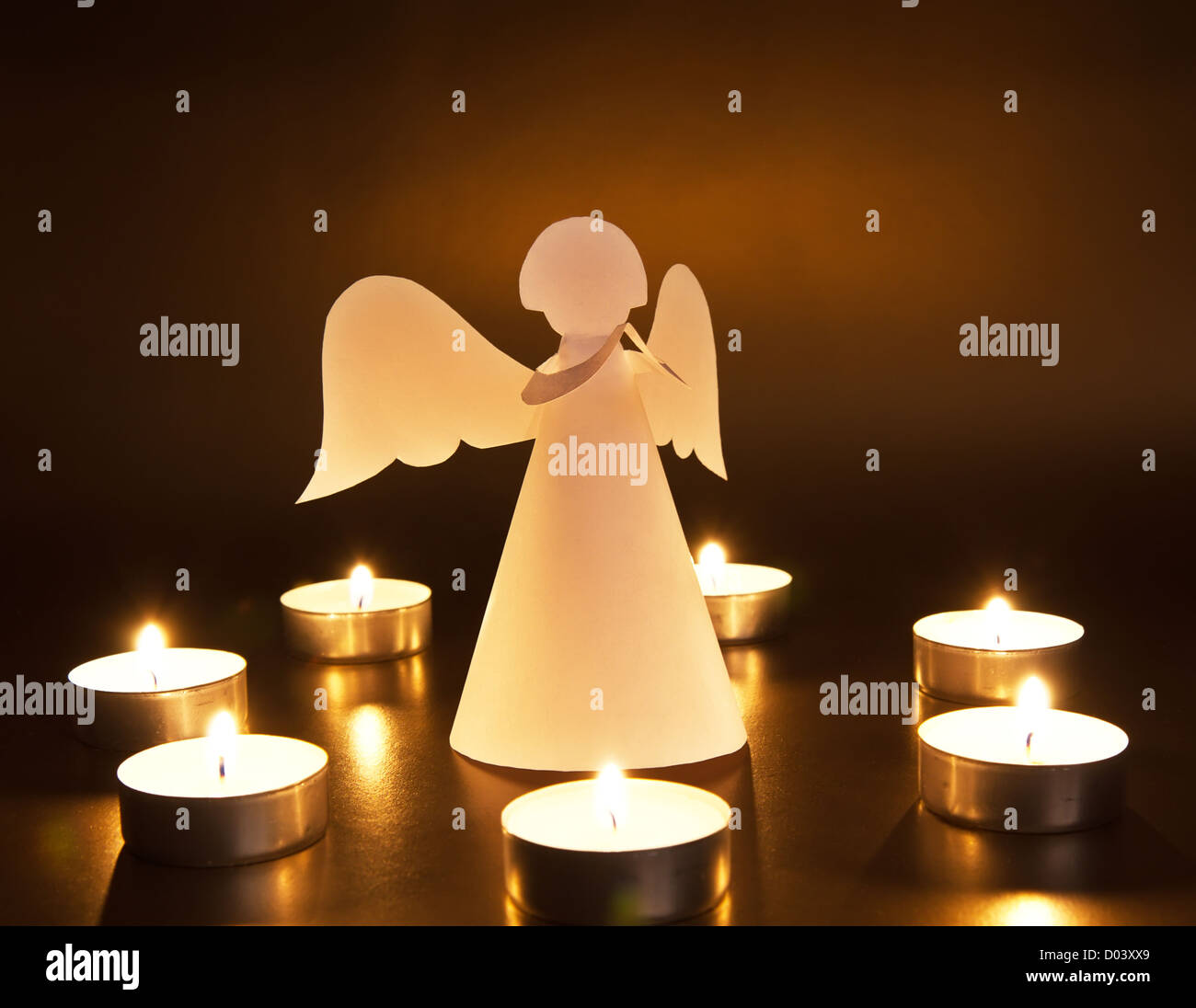 Weihnachtsengel mit Kerzen auf dunklem Hintergrund Stockfoto
