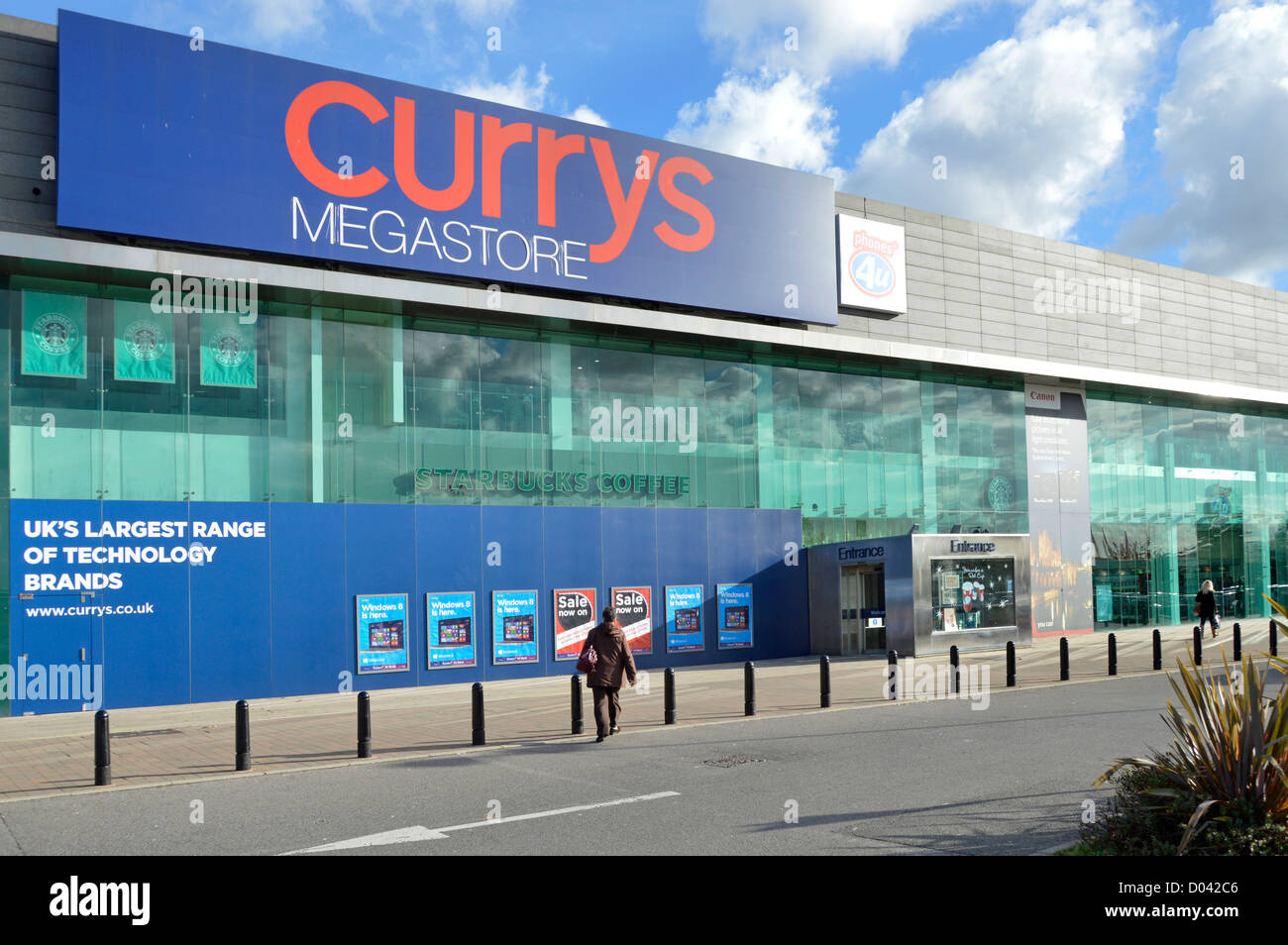 Frau-Shopper zu Fuß in Richtung Currys Megastore im Retailpark am See Stockfoto