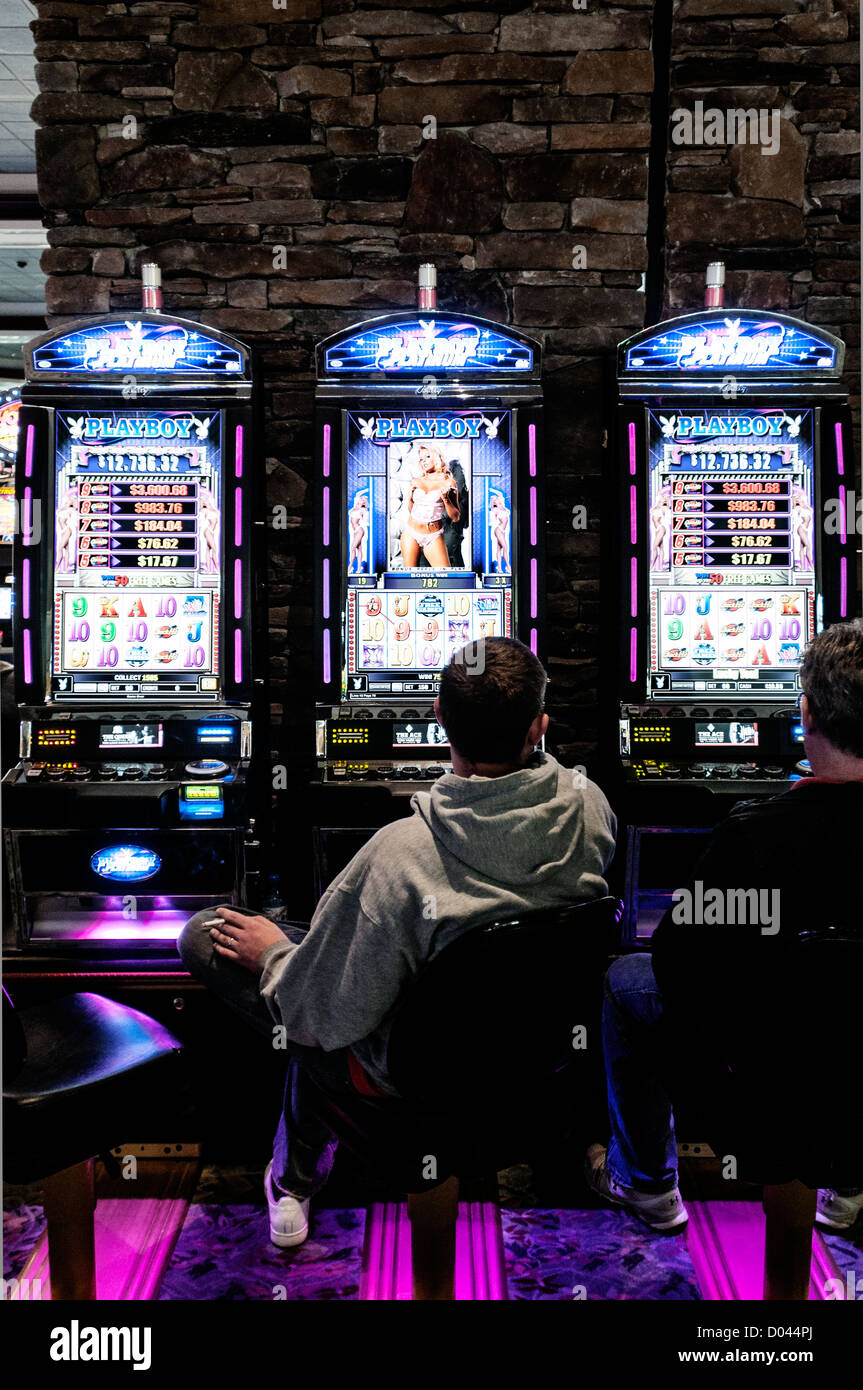 Männer sitzen an Spielautomaten im Foxwoods Resort Casino, Ledyard, Connecticut, USA Stockfoto