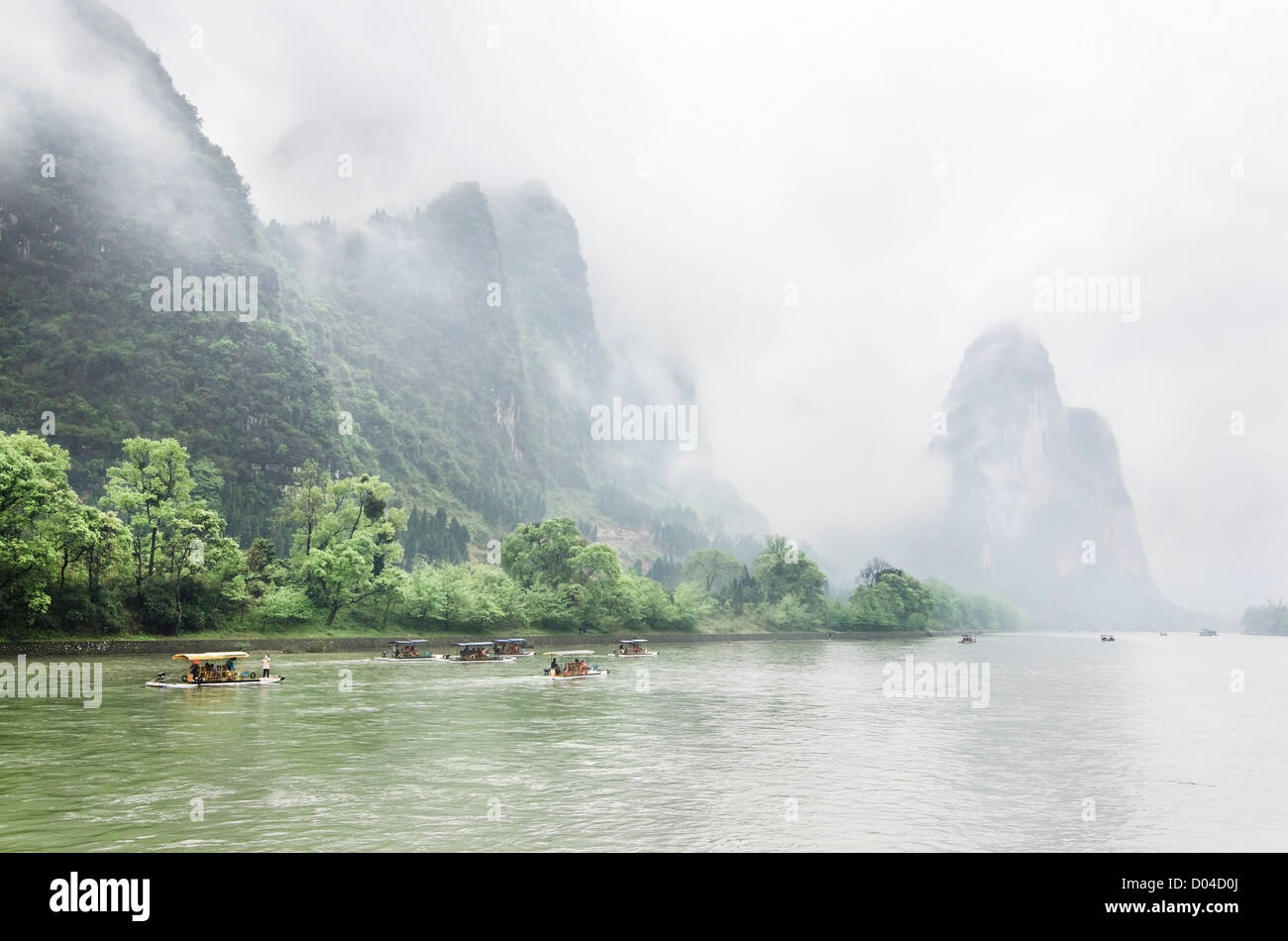 Ausflugsboote auf Li-Fluss durch Karstlandschaft umgeben von Nebel Stockfoto