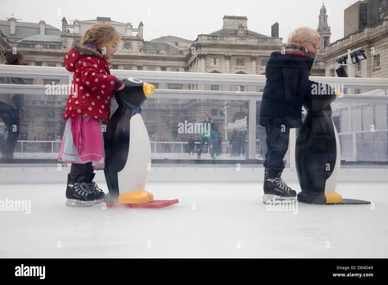London, UK. 16. November 2012. Kinder lernen, mit Hilfe eines Pinguins auf dem Eis Schlittschuh laufen, als Somerset House verwandelt ihren Garten in eine Eisbahn für den Winter für die Öffentlichkeit zugänglich ist. Bildnachweis: Amer Ghazzal / Alamy Live News Stockfoto