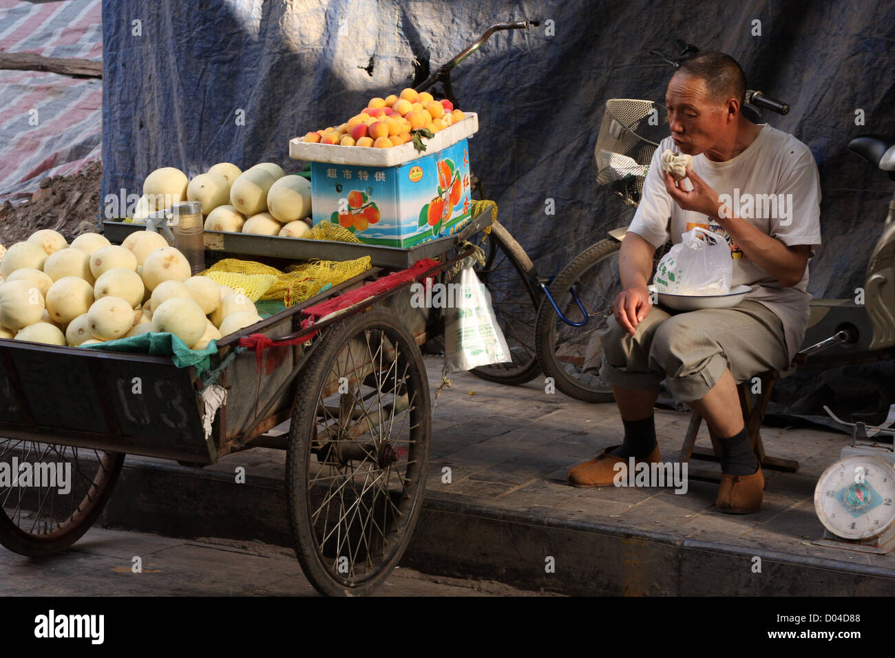 Chinesisches Obst-Verkäufer sein Essen auf dem Markt im muslimischen Viertel von Xian Stockfoto