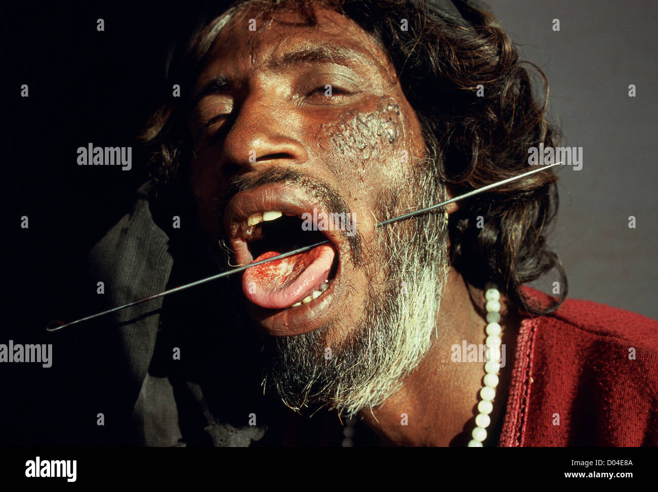 Fakir mit einer Nadel piercing seine Wange (Indien) Stockfoto