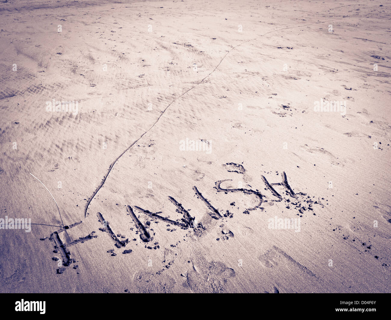 Ende der Linie im Sand durch das Wort fertig markiert. Stockfoto