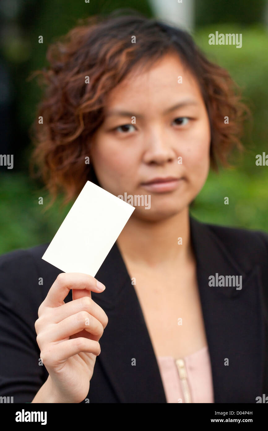 Geschäftsfrau hält eine Namenskarte Stockfoto