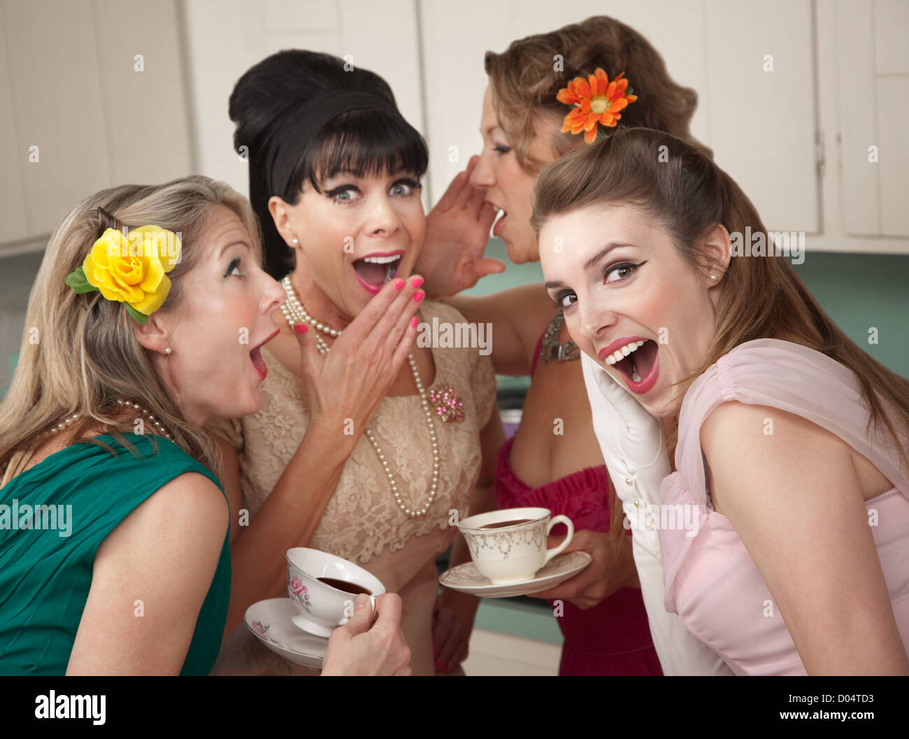 Gruppe von vier Retro-Mode Hausfrauen erzählen Geheimnisse in der Küche Stockfoto