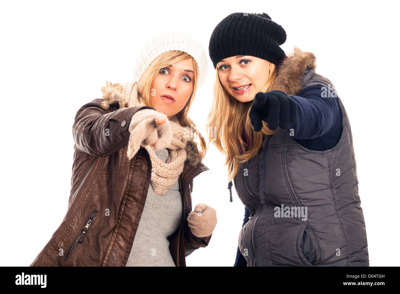 Zwei Mädchen überrascht in Winterkleidung zeigen Sie isoliert auf weißem Hintergrund. Stockfoto