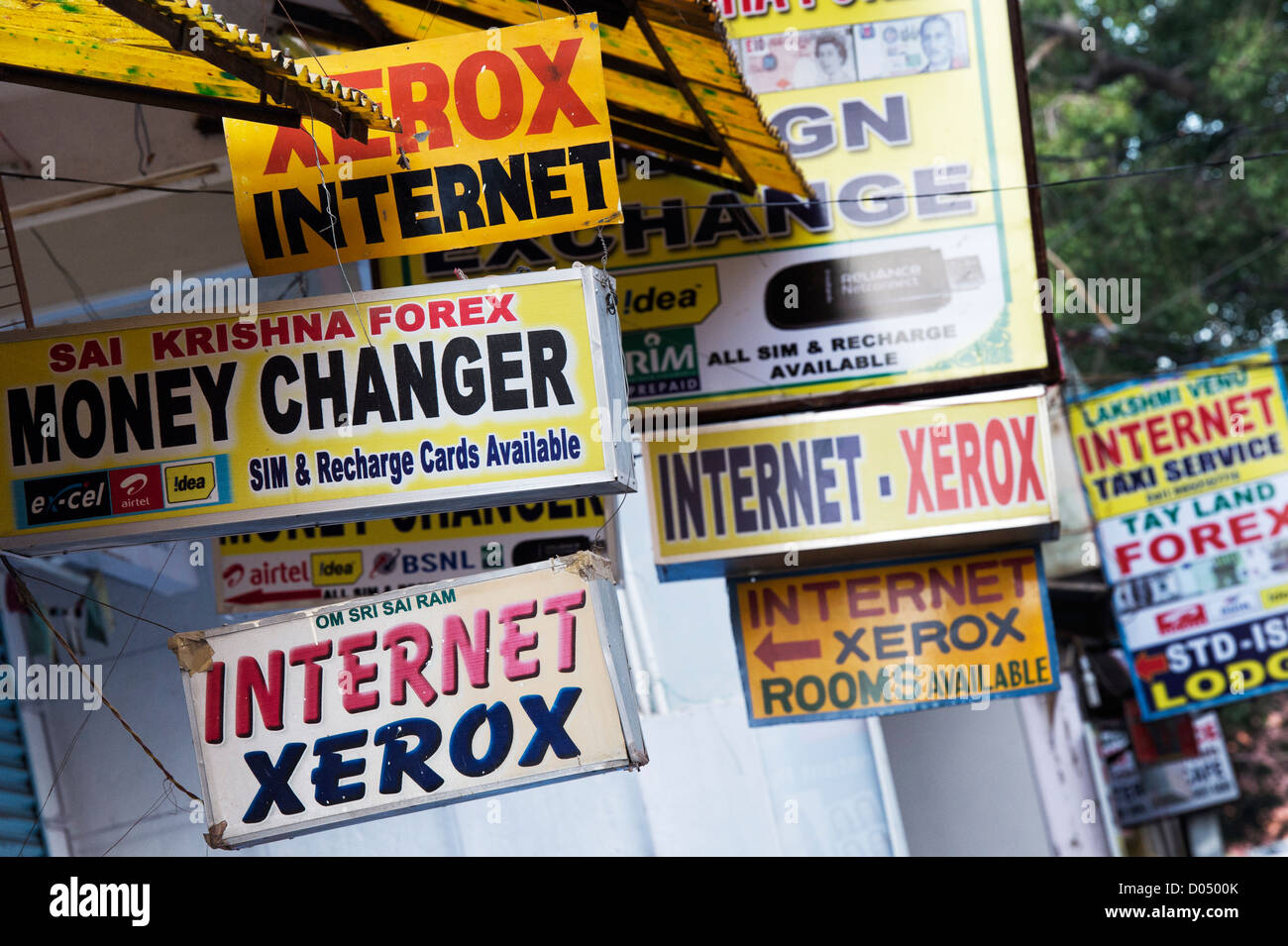 Indische Internet, Xerox und Geldwechsler Schilder entlang einer indischen Straße. Puttaparthi, Andhra Pradesh, Indien Stockfoto