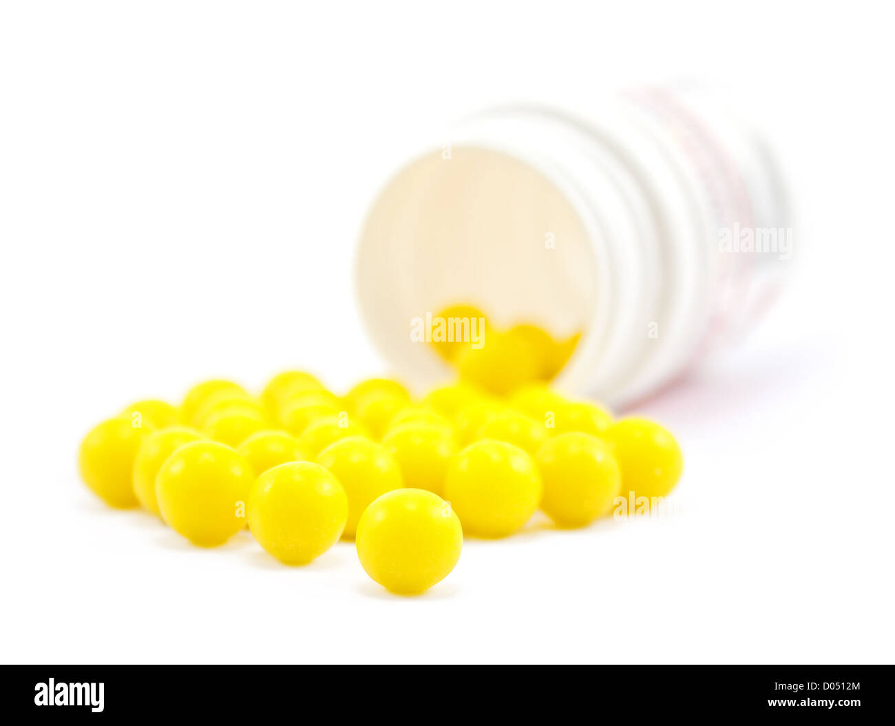 Gelben Pillen von Flasche auf dem weißen Stockfoto