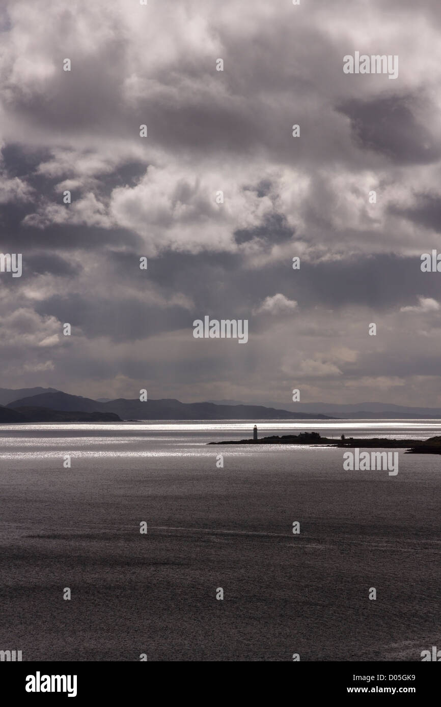 Dramatische Himmel und Sonne über Sound of Sleat mit Isle Ornsay Leuchtturm in Ferne, Schottland, Großbritannien Stockfoto
