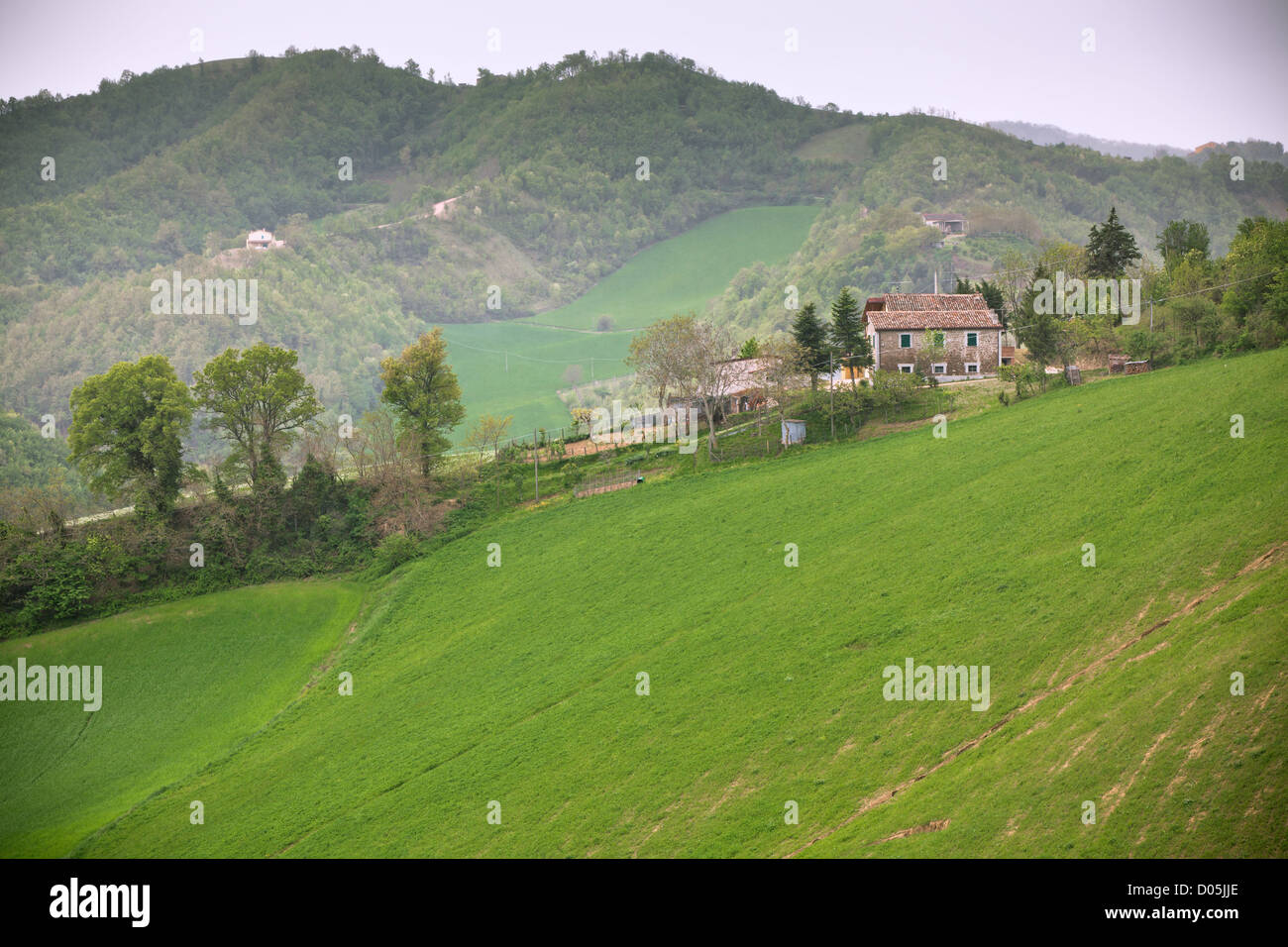 Schlechtes Wetter in Italien Ackerland. Grüne Hügel und Haus - getönten Vignetted Bild Stockfoto