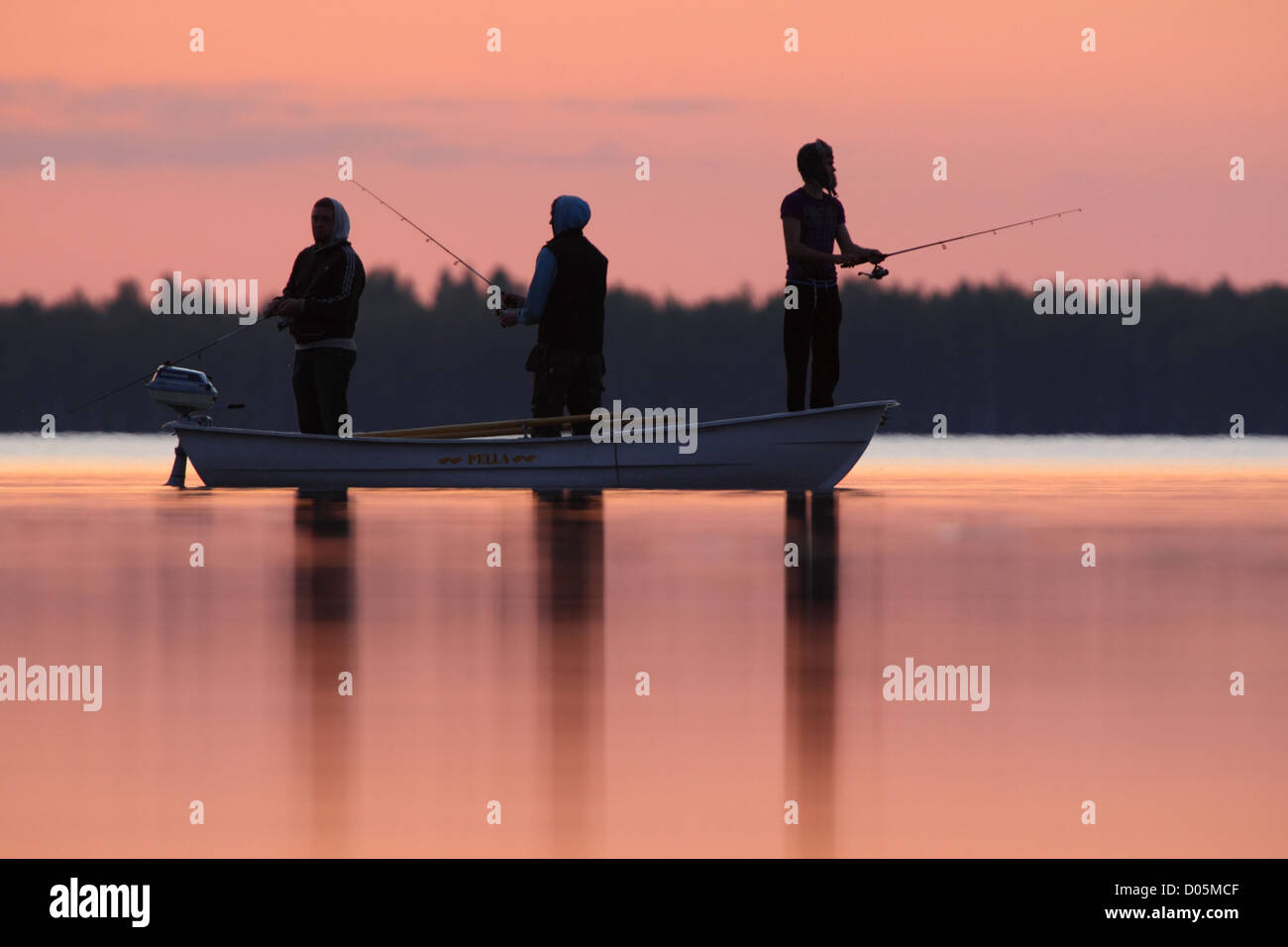 Jungen nach Sonnenuntergang am See angeln. Stockfoto