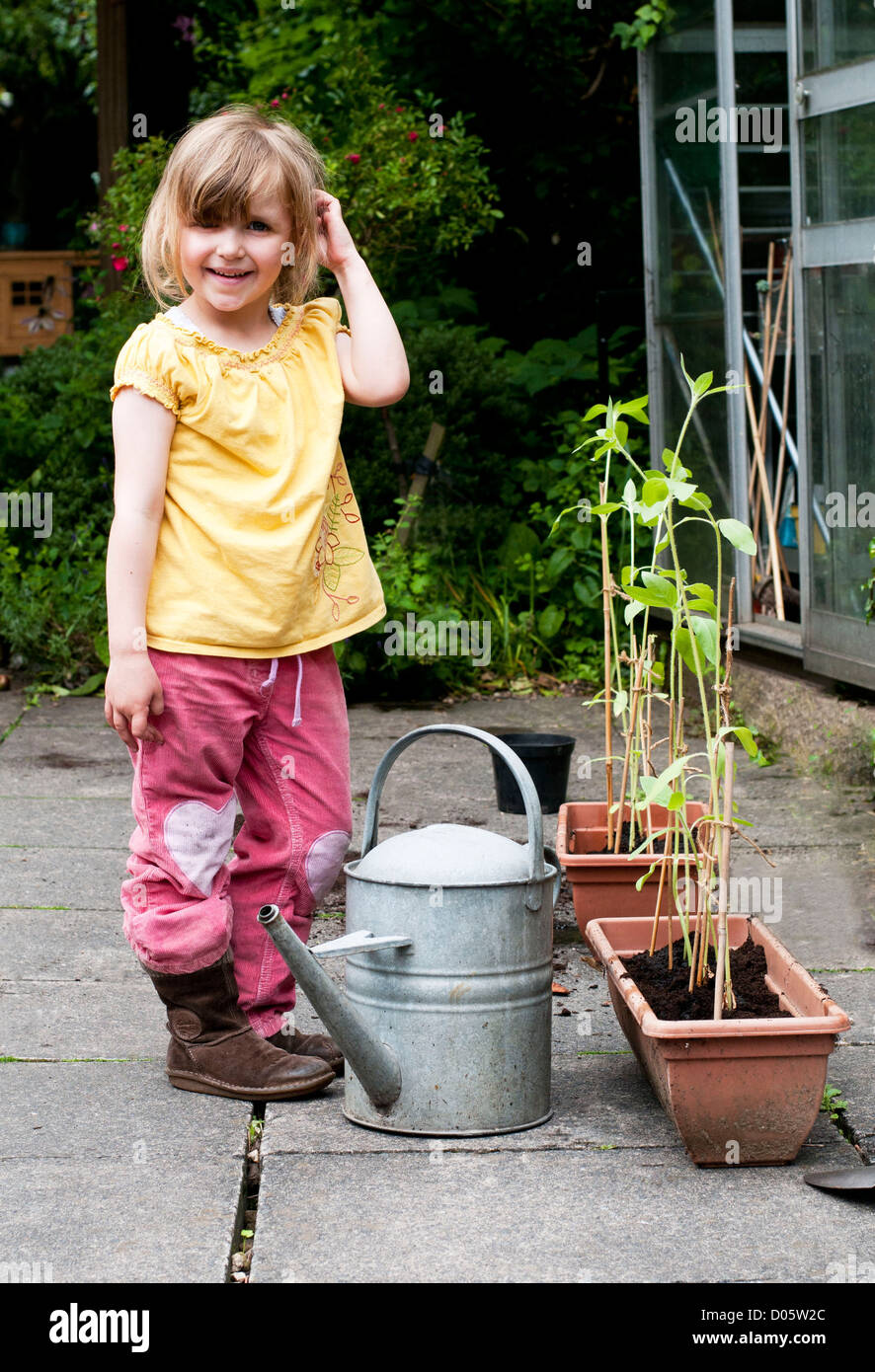 Kleines Mädchen im Garten und Bewässerung von Pflanzen Stockfoto