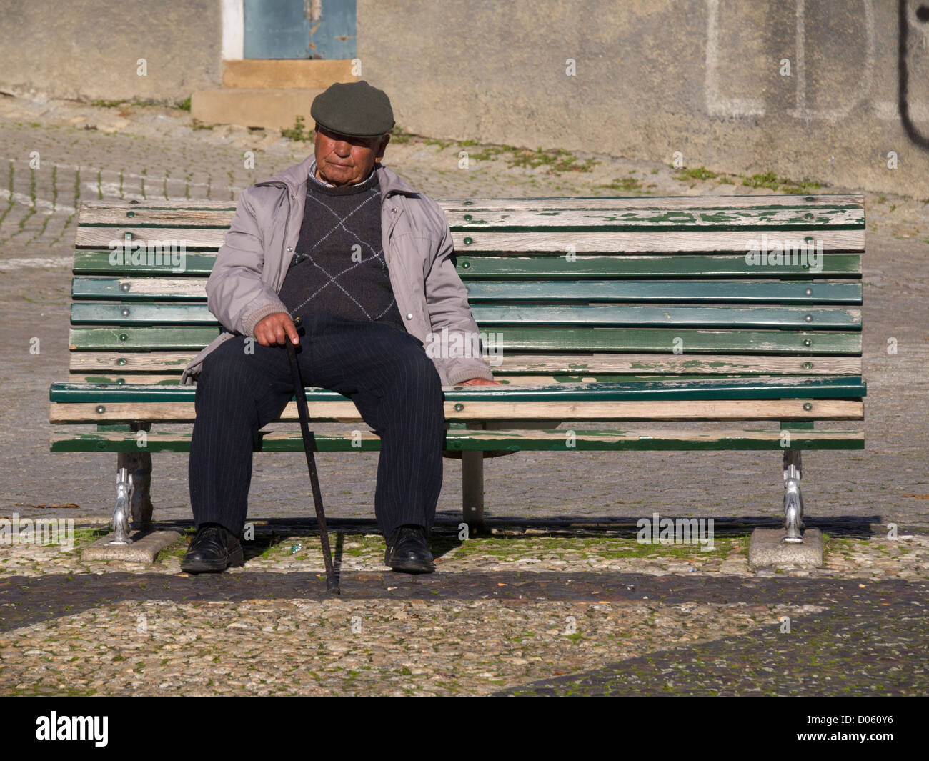 Einsamer alter Mann sitzt auf einer Parkbank Stockfoto