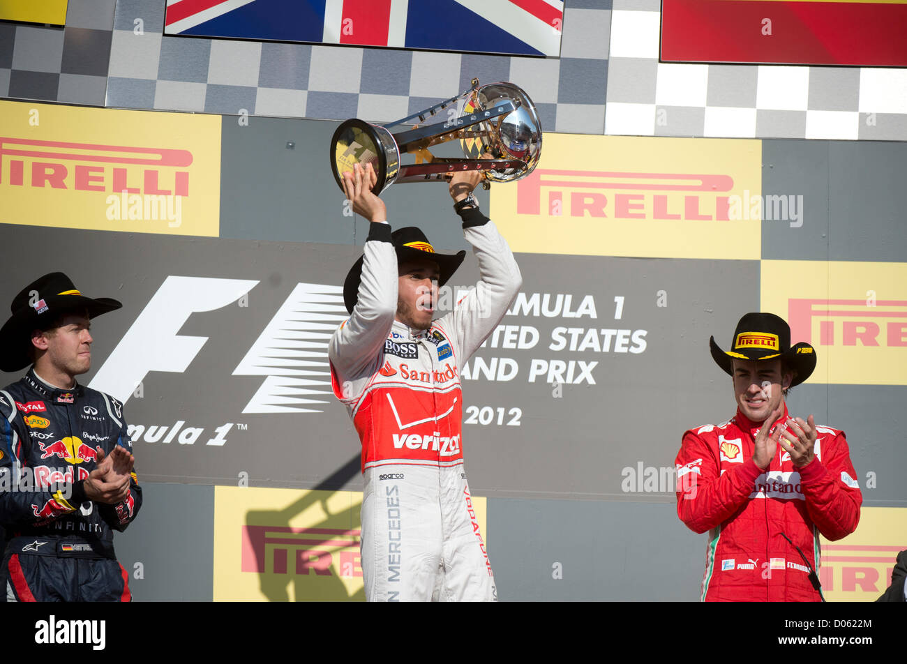 Siegreiche Fahrer Lewis Hamilton (c) mit Sebastian Vettel (l) und Fernando Alonso (r) in den Vereinigten Staaten-Grand-Prix in Austin TX Stockfoto