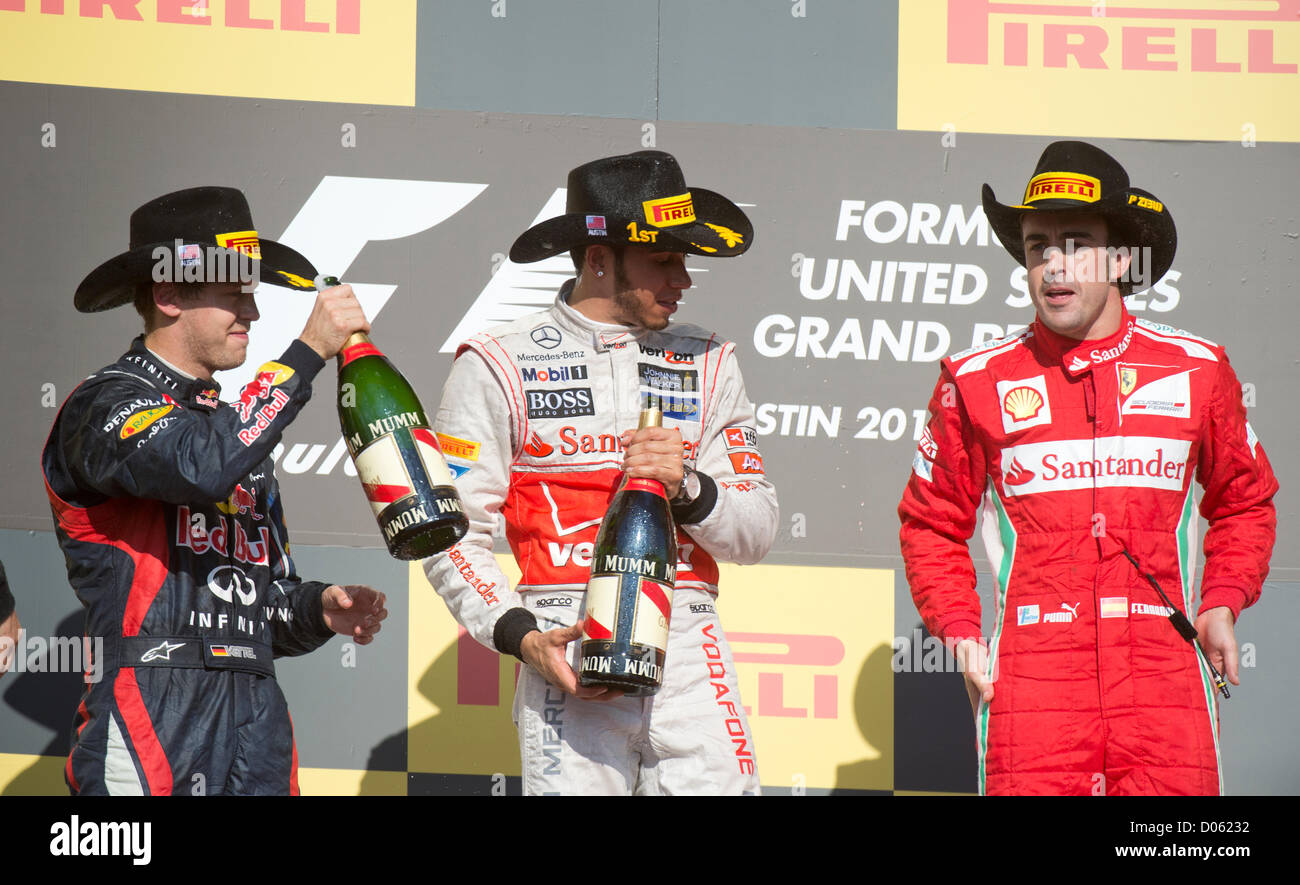 Siegreiche Fahrer Lewis Hamilton (c) mit Sebastian Vettel (l) und Fernando Alonso (r) in den Vereinigten Staaten-Grand-Prix in Austin TX Stockfoto