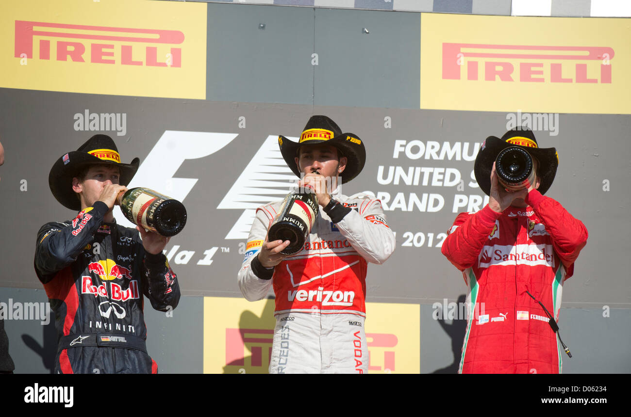 Siegreiche Fahrer Lewis Hamilton (c) mit Sebastian Vettel (l) und Fernando Alonso (r) in den Vereinigten Staaten-Grand-Prix in Austin TX Stockfoto