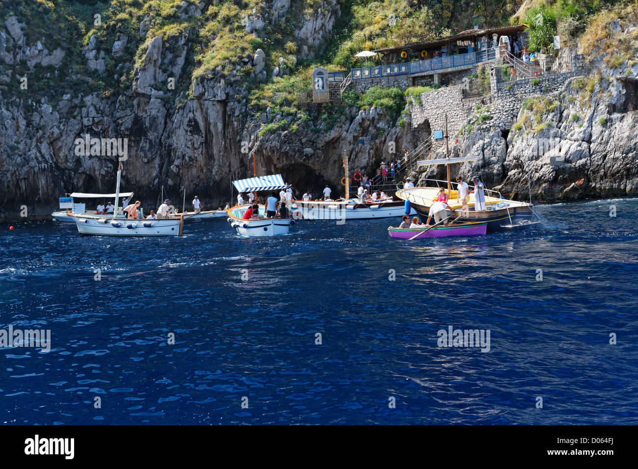 Besucher-Übertragung auf kleinen Booten am Eingang der blauen Grotte, Anacapri, Kampanien, Italien Stockfoto