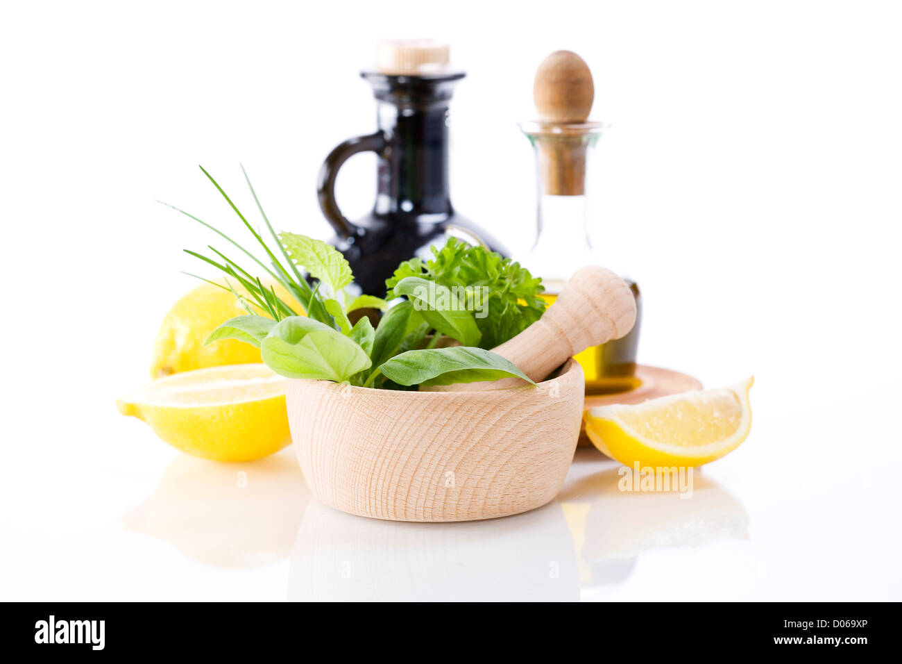 Olivenöl, Essig, heilende Kräuter und Zitrone über weiß Stockfoto