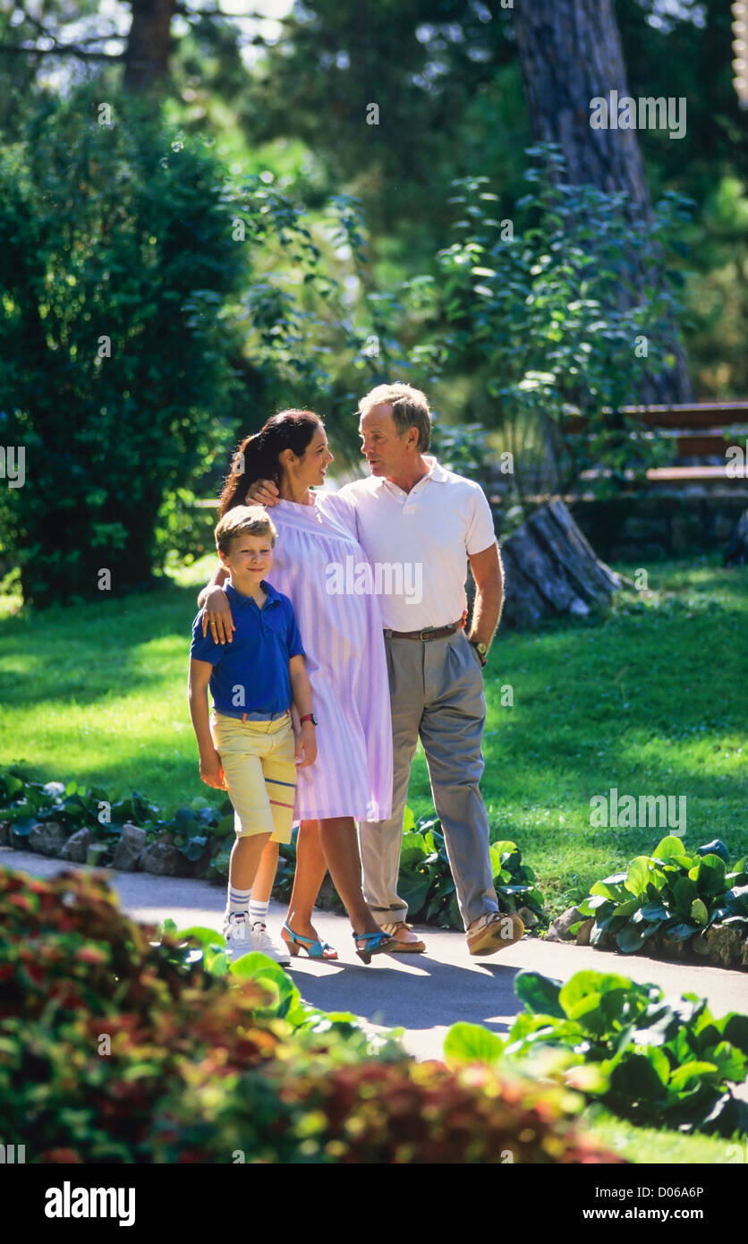 Paar mit schwangeren und jungen einen Spaziergang im park Stockfoto