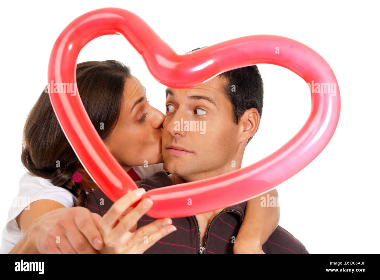 Junge Paar küssen durch Ballon Herz Überraschung isoliert auf weißem Hintergrund Stockfoto