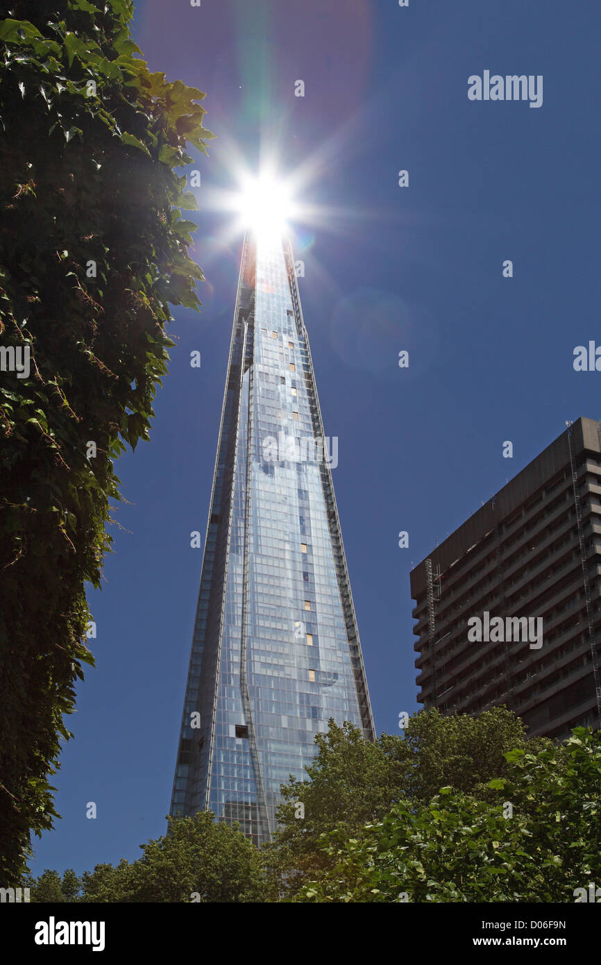 Sonne spiegelt, von Shard of Glass, London, entworfen von Renzo Piano zeigt Bäume und Guys Hospital im Vordergrund Stockfoto