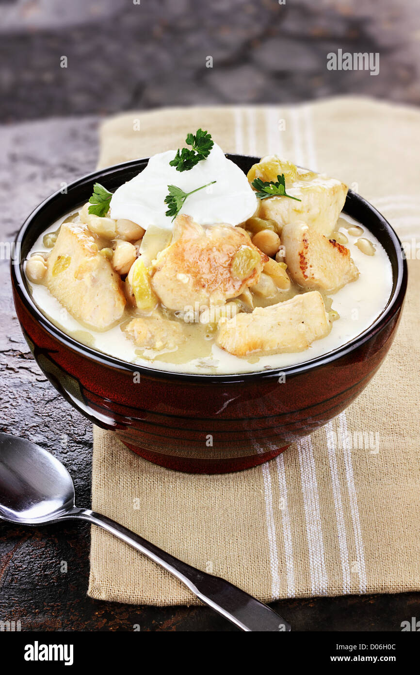 Eine leckere Schale mit weißes Huhn Chili garniert mit saurer Sahne und Petersilie geringe Schärfentiefe. Stockfoto