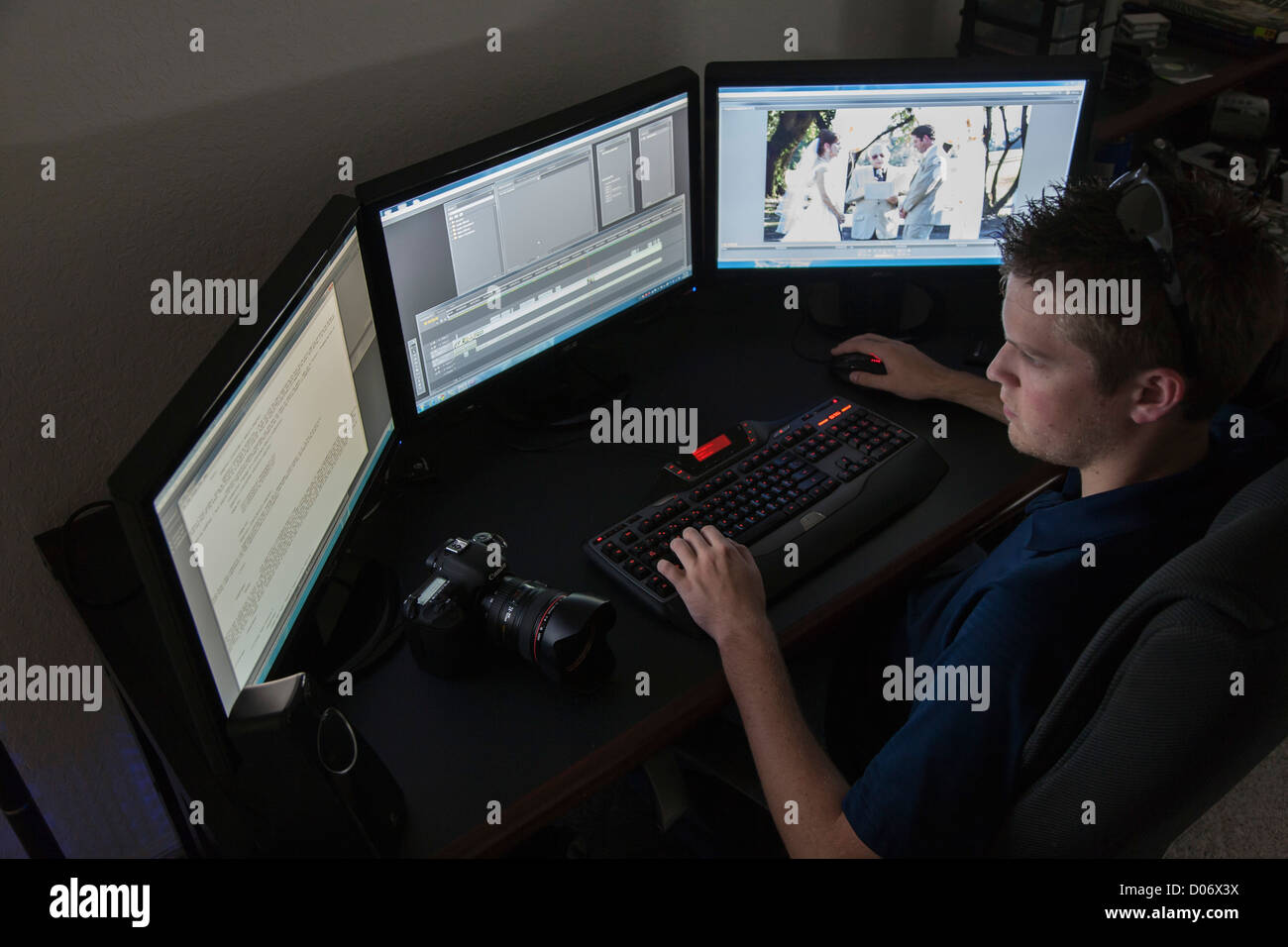 Jungen Erwachsenen männlichen Videofilmer bearbeiten ein Hochzeitsvideo auf seinem Computersystem Stockfoto