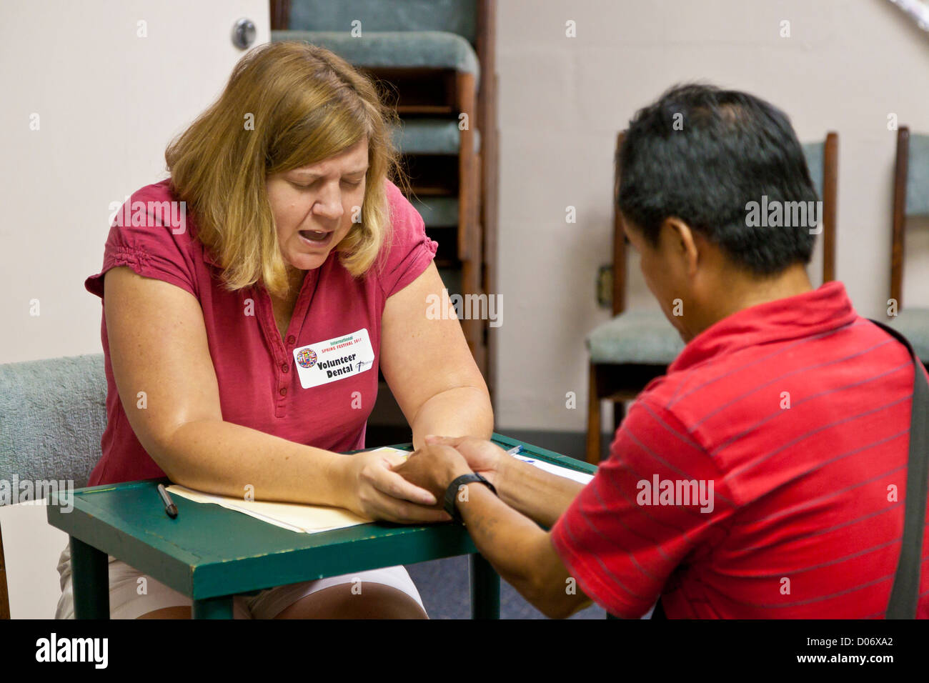 Weibliche Freiwillige bietet spirituelle Unterstützung und Gebet für Patienten in Mission lächelt mobile Zahnklinik in Temple Terrace, FL Stockfoto