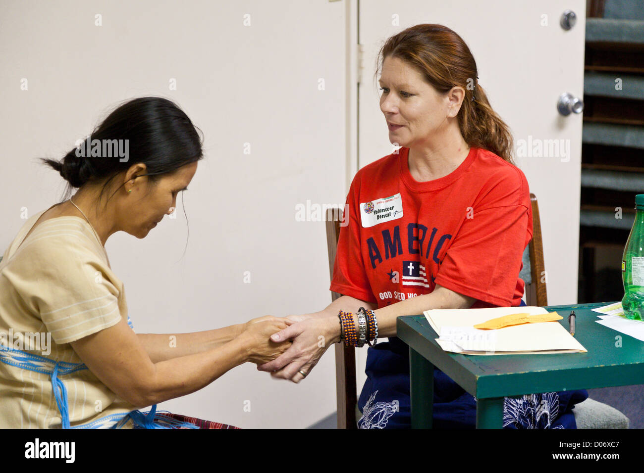 Weibliche Freiwillige bietet spirituelle Unterstützung und Gebet für Patienten in Mission lächelt mobile Zahnklinik in Temple Terrace, FL Stockfoto