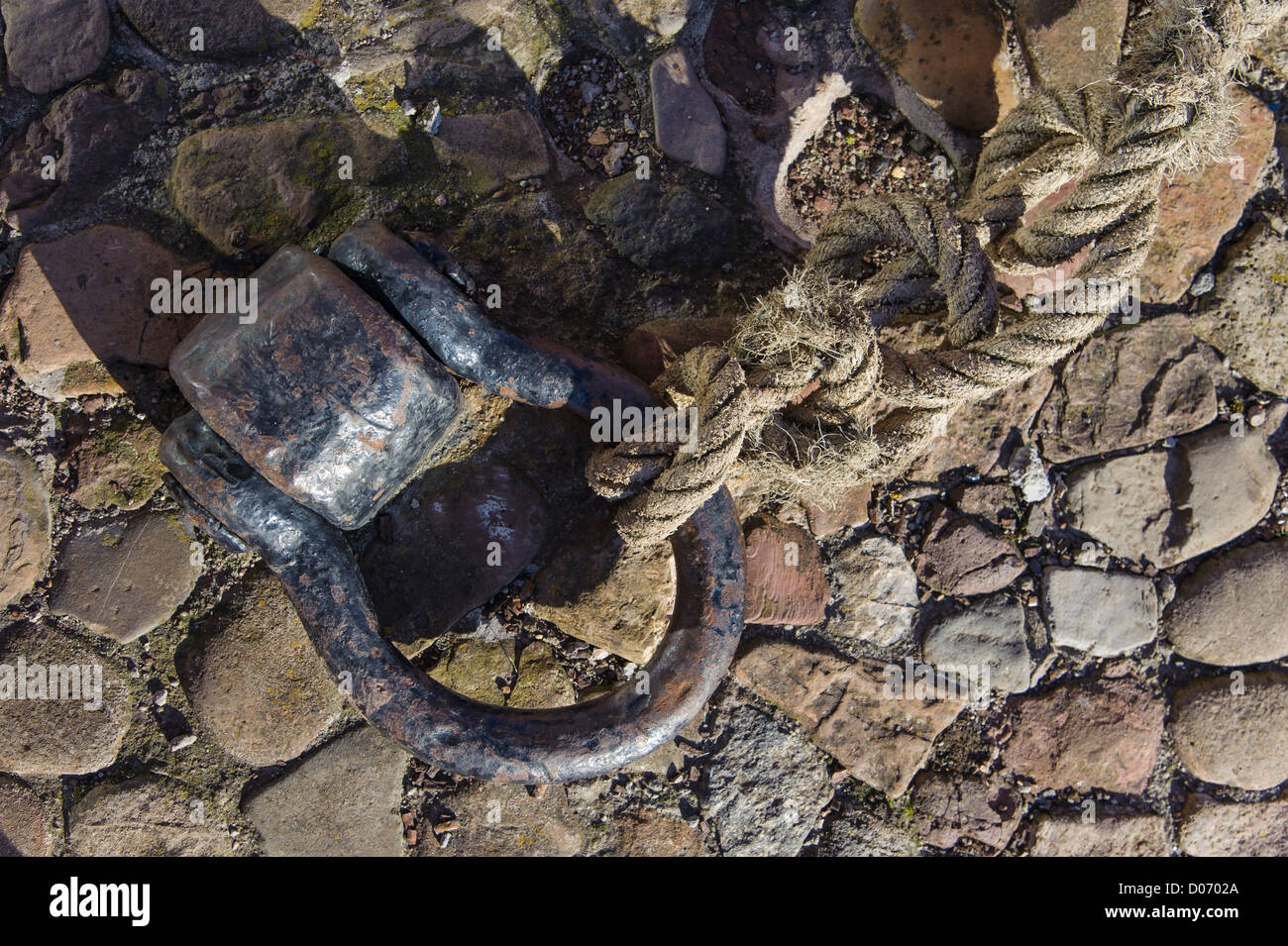 Details eines Bügeleisens festmachen, Schäkel und Seil am alten Hafen in Dunbar, Schottland. Stockfoto