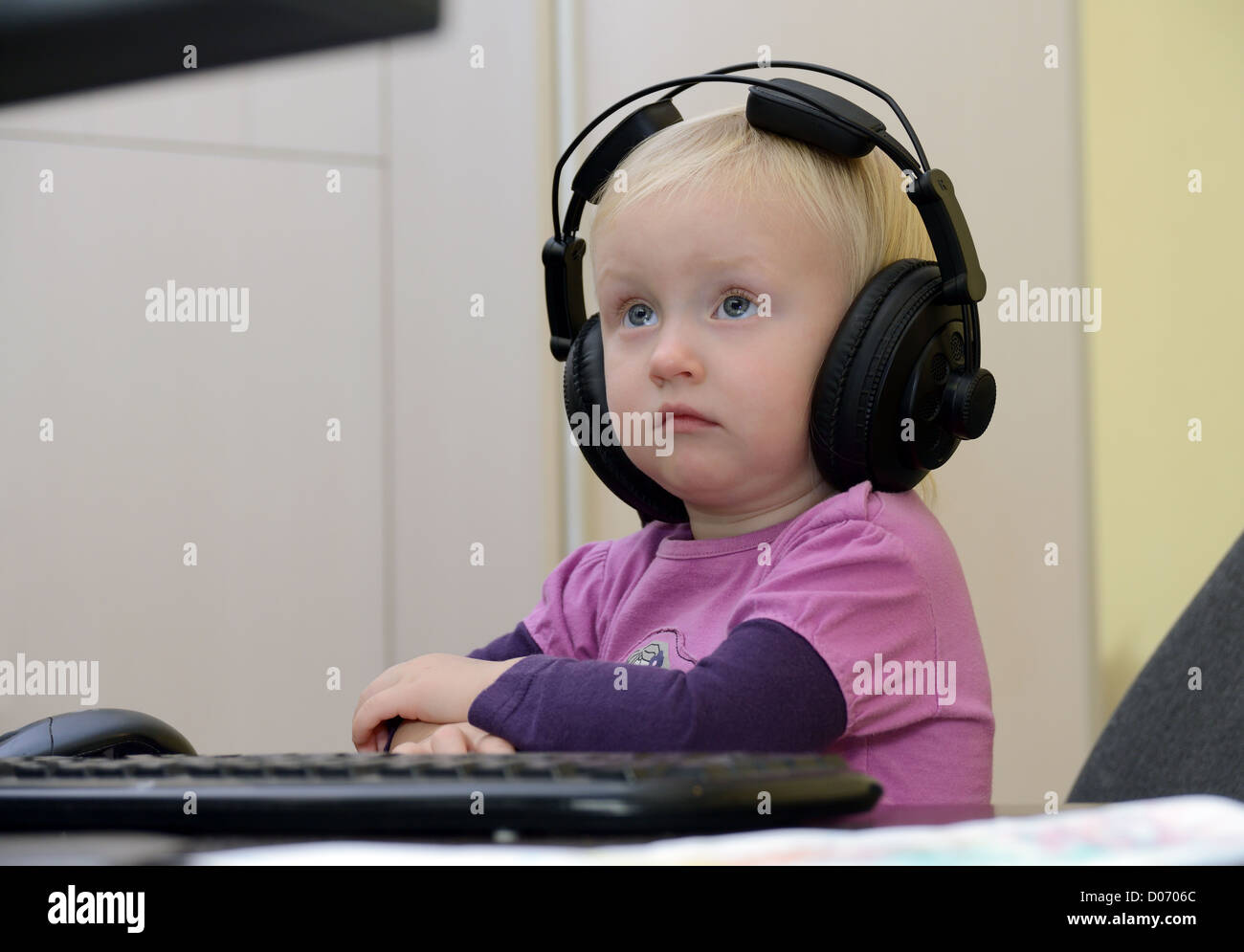 kleines Mädchen mit Kopfhörern auf dem Computer lernen Stockfoto