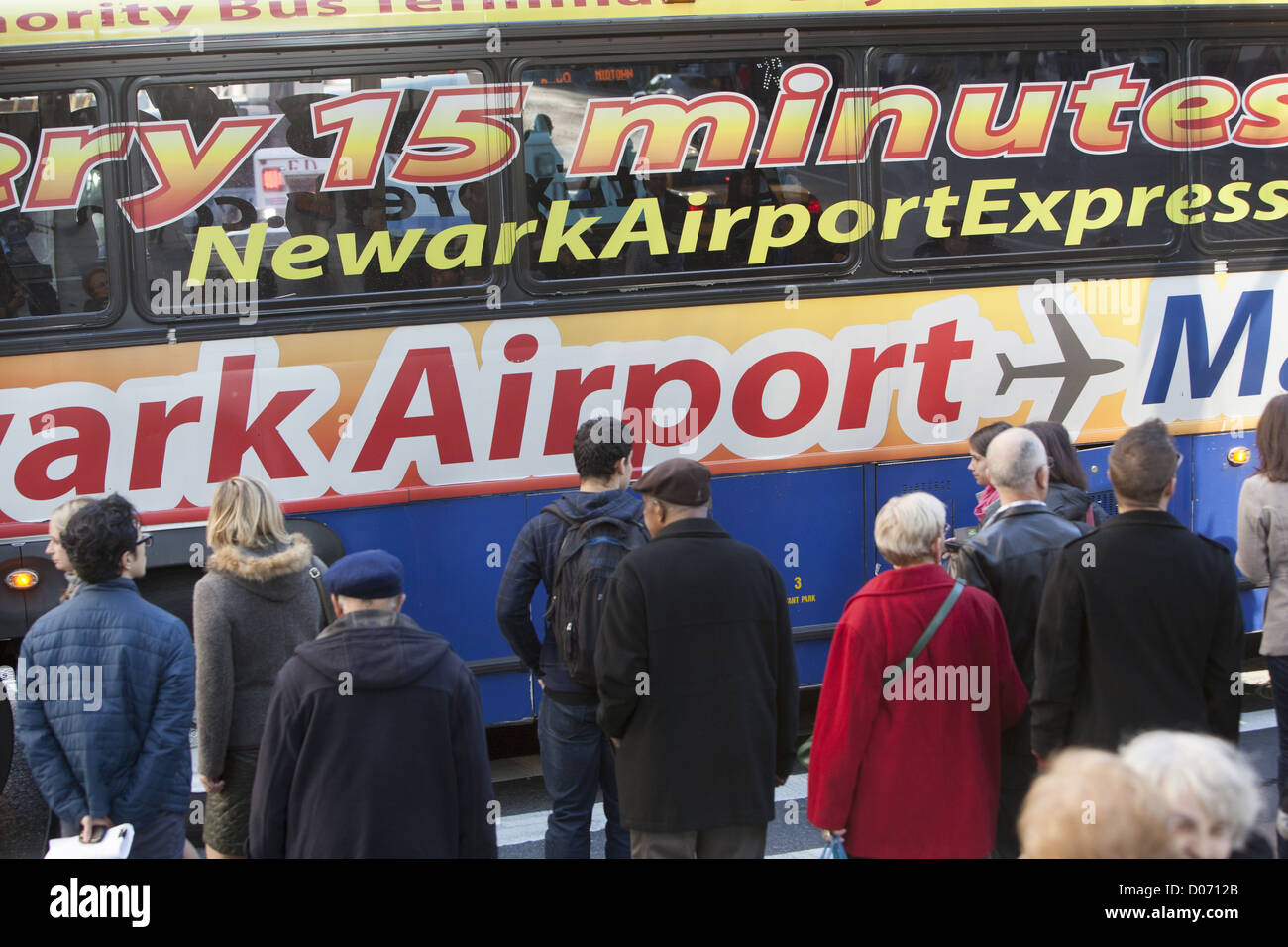 Fußgänger warten das Spaziergang-Signal am 34. und vergeht Broadway als Flughafenbus pendelt Reisende zum Flughafen Newark. Stockfoto